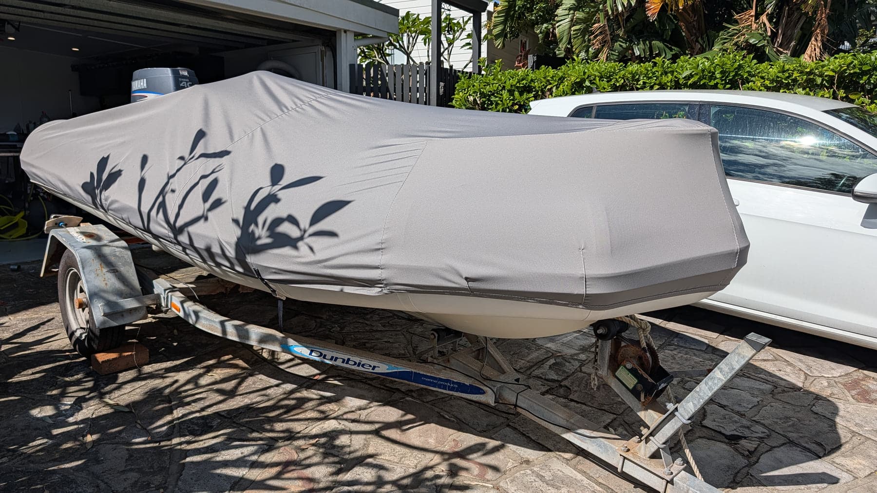 Fitted cover protecting a boat stored on its trailer